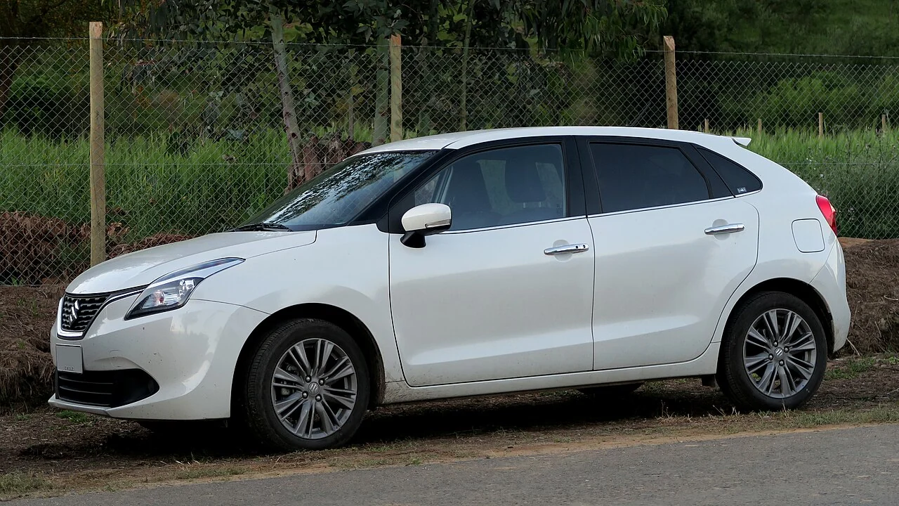 Representative photo of a white Maruti Suzuki Baleno hatchback from the side; not a specific booking vehicle